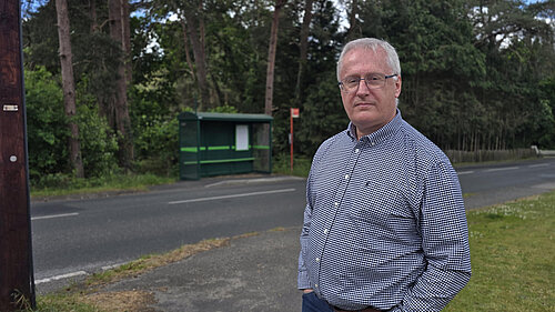 Andrew Barham standing by a local bus stop